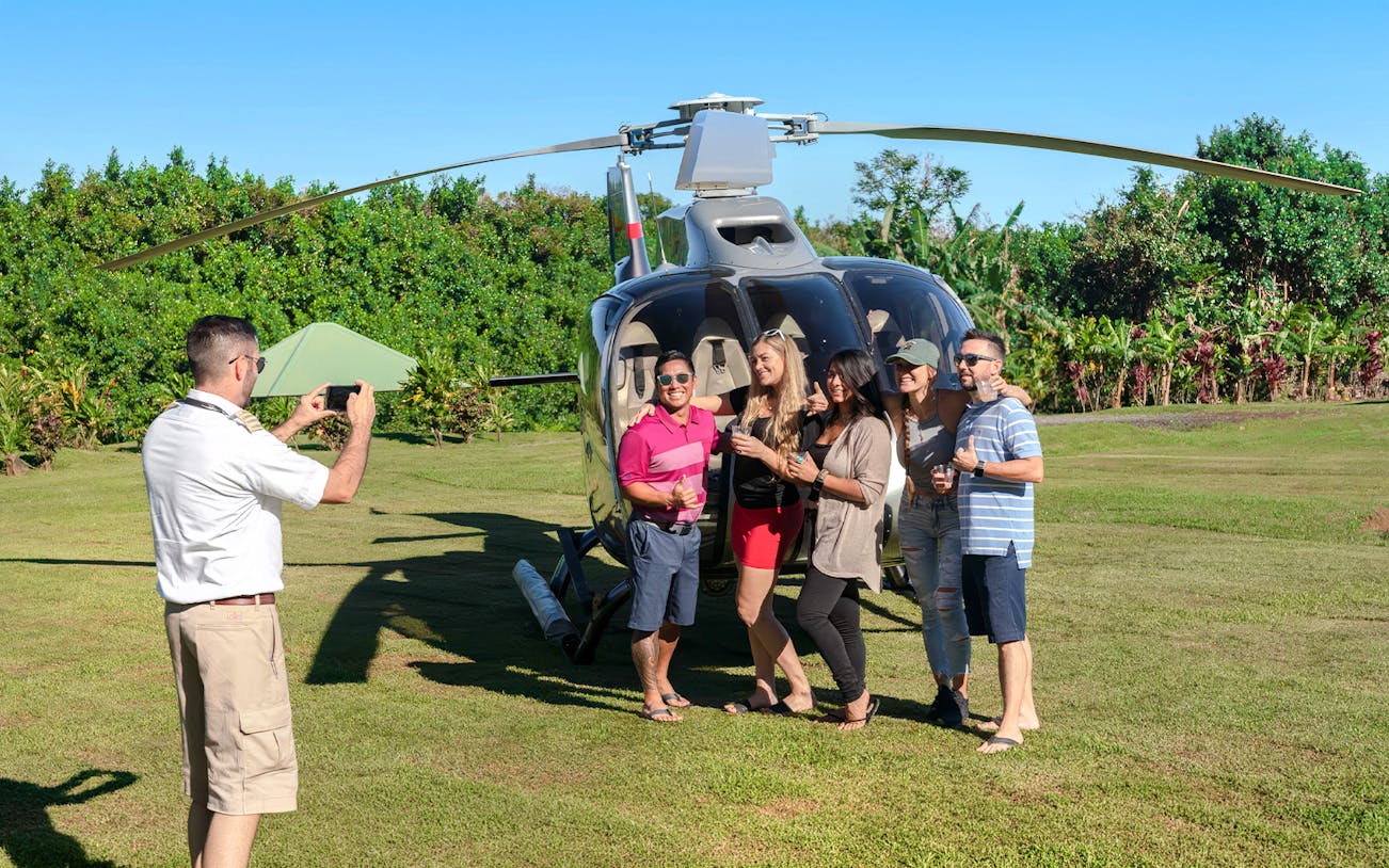 Group posing by helicopter on Hana Rainforest tour, Hawaii.