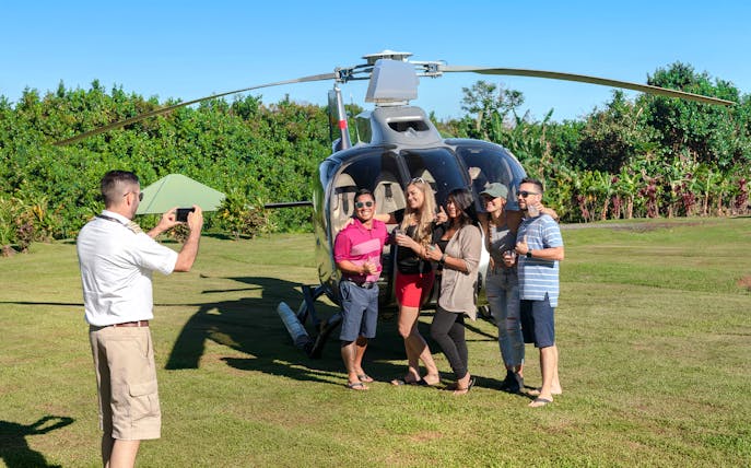 Group posing by helicopter on Hana Rainforest tour, Hawaii.