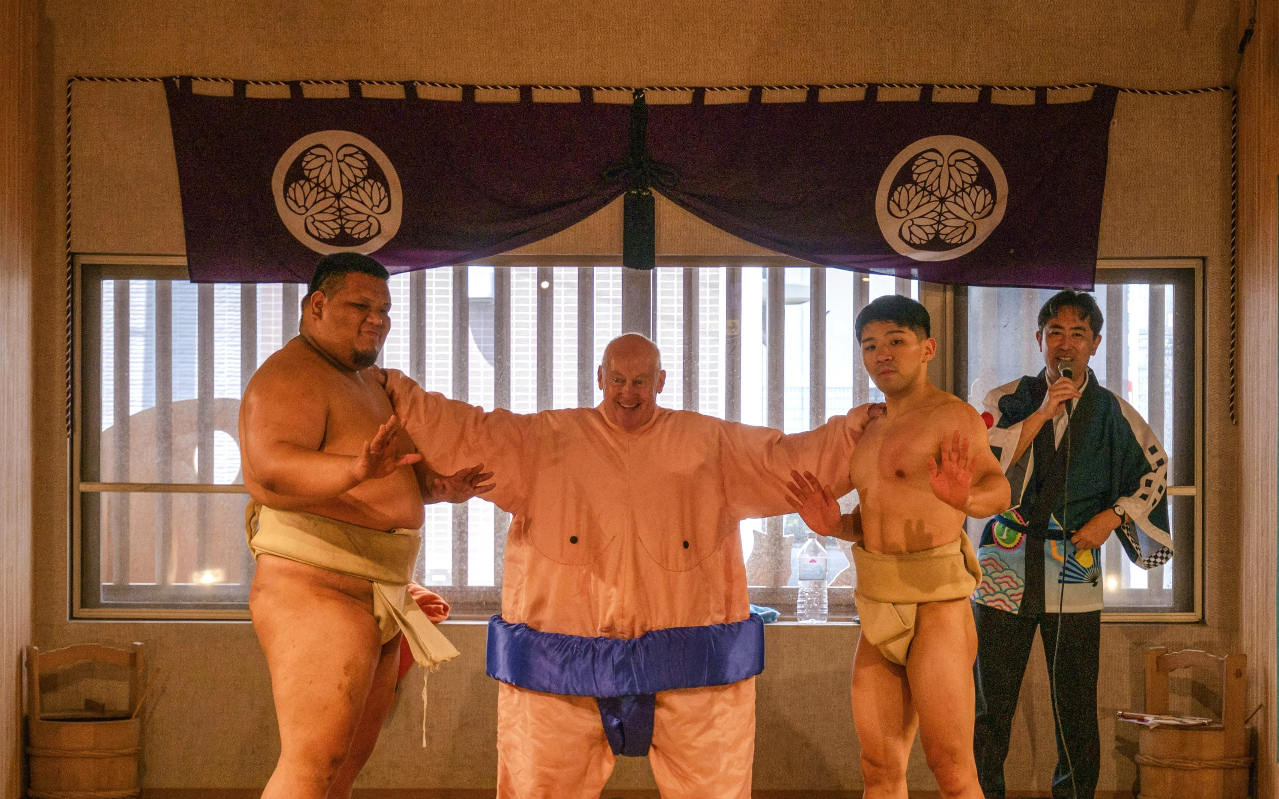 Sumo wrestlers and participant in costume during Tokyo family sumo workshop.