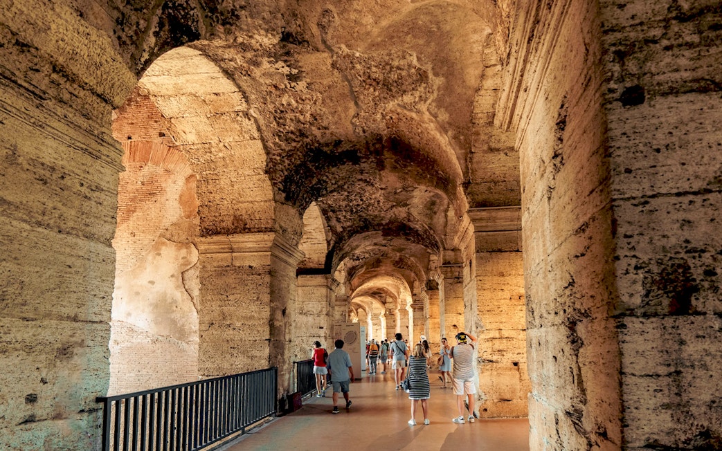 Visitors walking through the ancient corridors of the Colosseum in Rome.