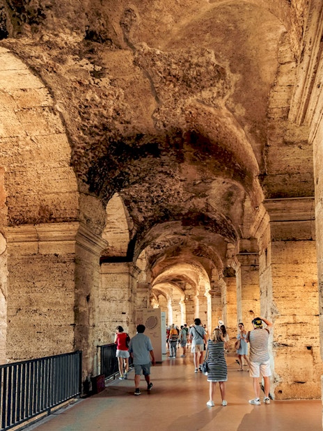 Visitors walking through the ancient corridors of the Colosseum in Rome.