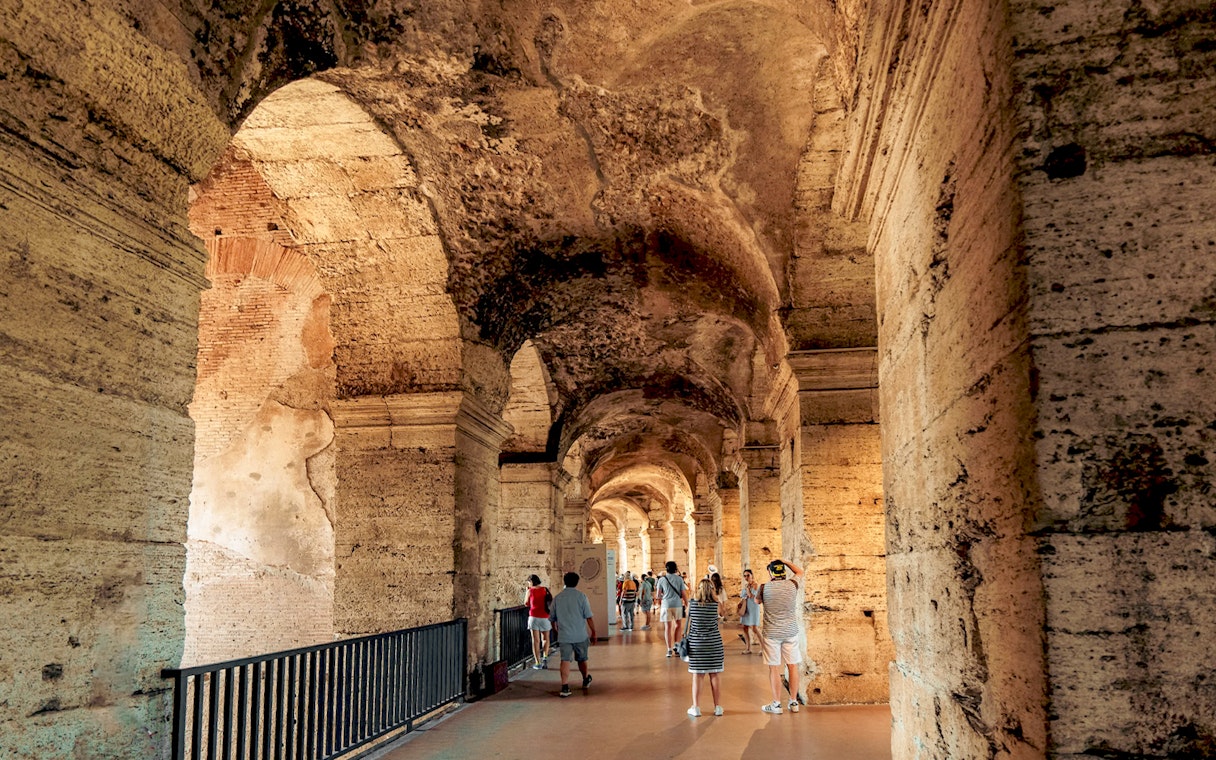 Visitors walking through the ancient corridors of the Colosseum in Rome.