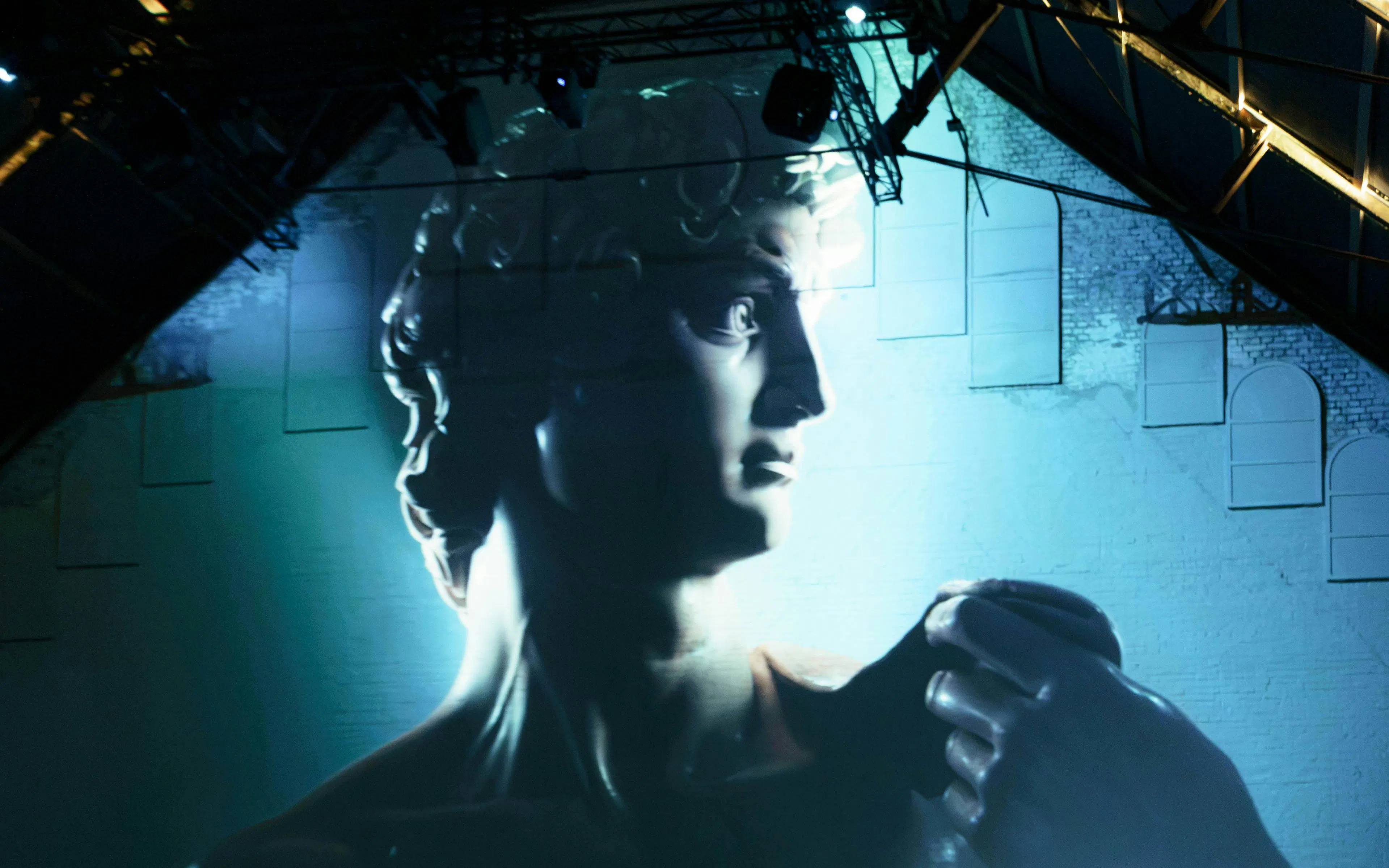 Michelangelo's David sculpture illuminated in a dark exhibition space.