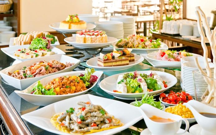 Buffet spread with various dishes at a lunch event in a scenic outdoor setting.