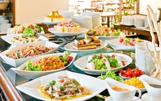 Buffet spread with various dishes at a lunch event in a scenic outdoor setting.