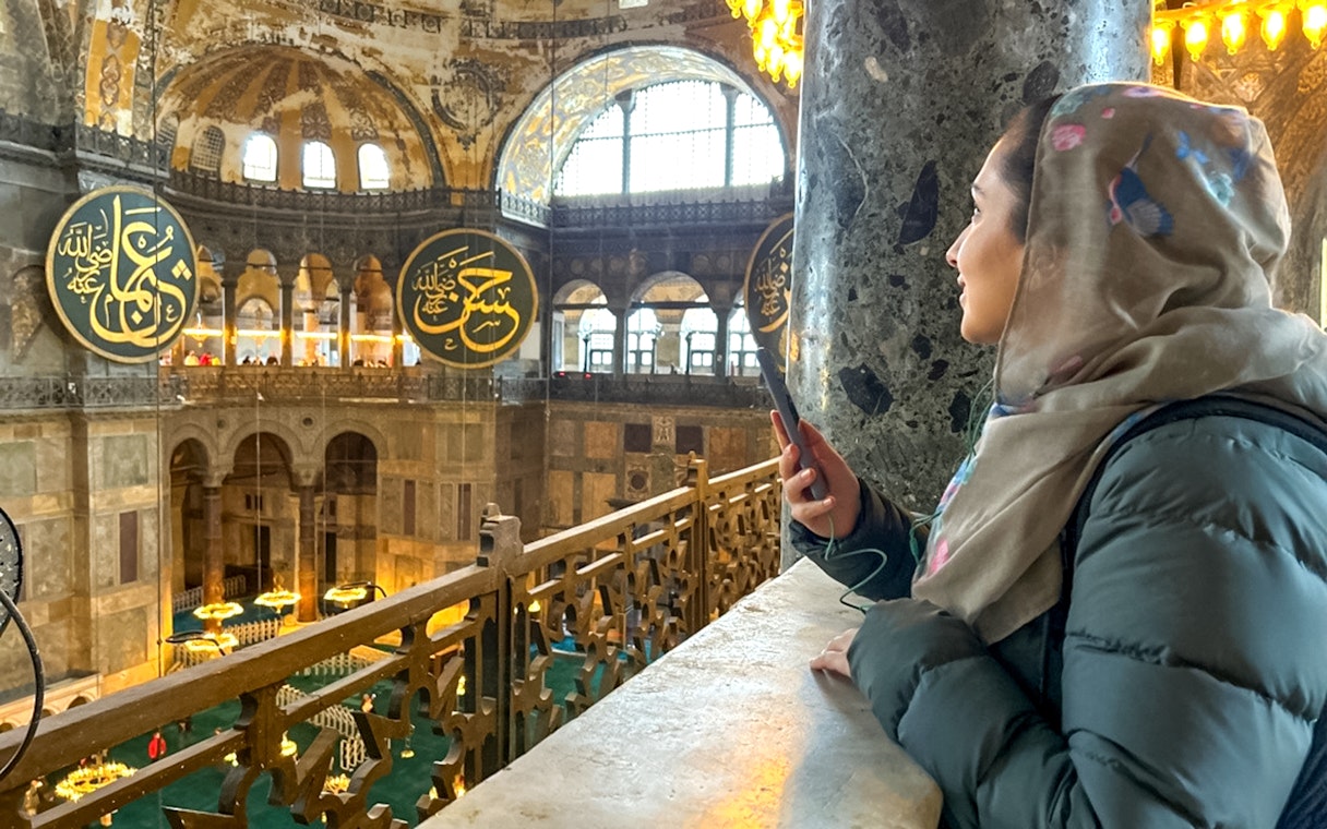 Visitor using audio guide inside Hagia Sophia, Istanbul.