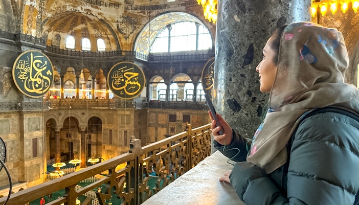 Visitor using audio guide inside Hagia Sophia, Istanbul.