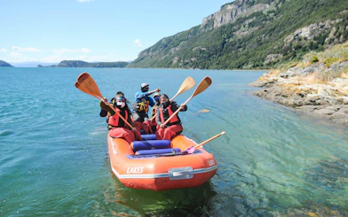 Group paddling in an inflatable boat on a lake in Tierra del Fuego National Park.