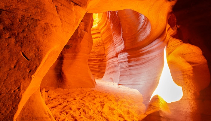 Antelope Canyon X sandstone formations with sunlight filtering through.