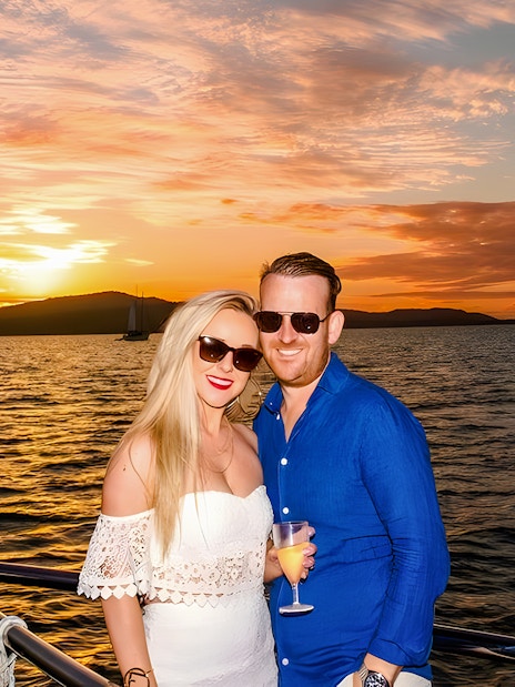 Couple enjoying a sundowner cruise at sunset, Airlie Beach.