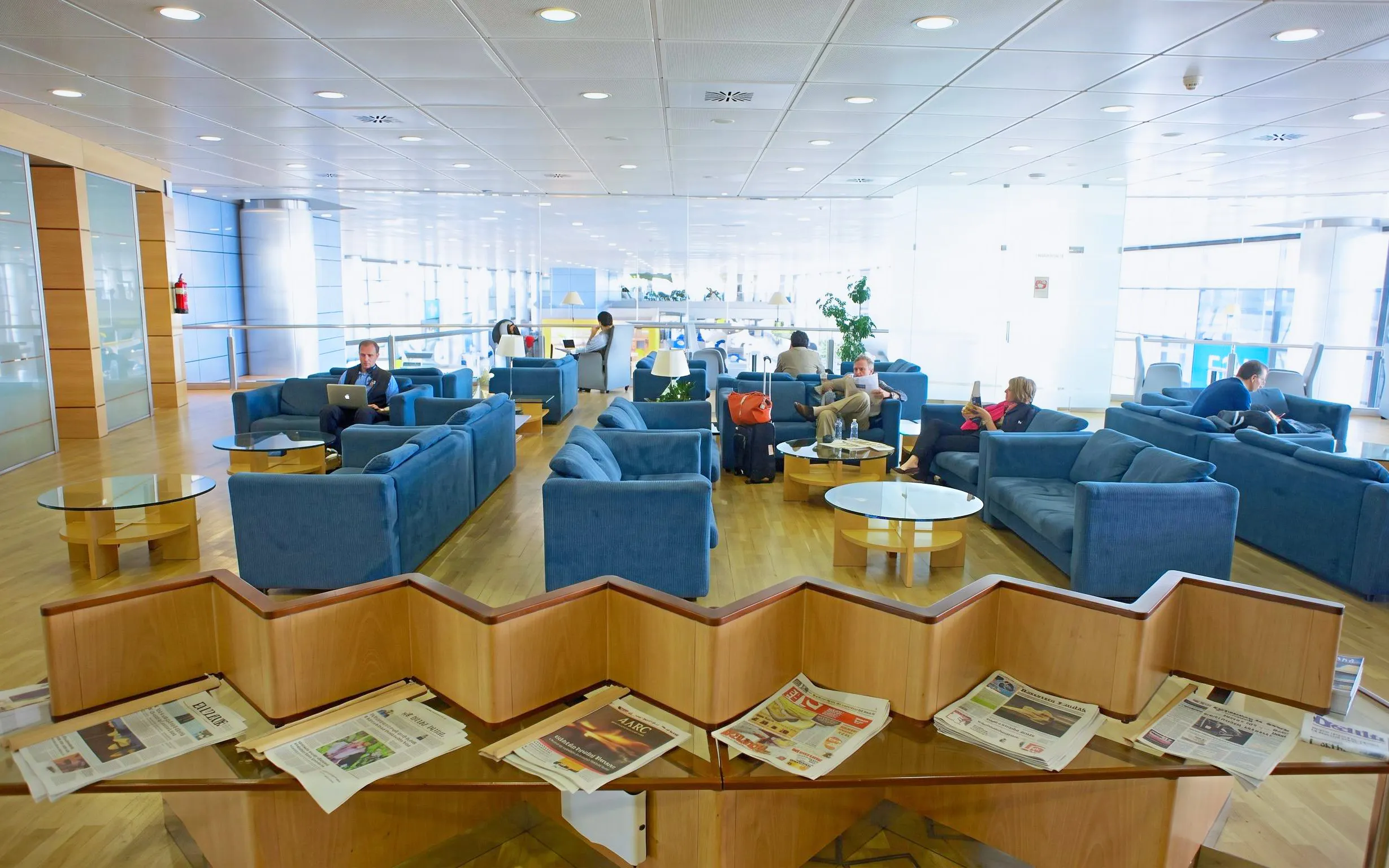 Sala VIP lounge with blue seating and newspapers, Adolfo Suarez-Barajas Airport, Terminal 3, Madrid.