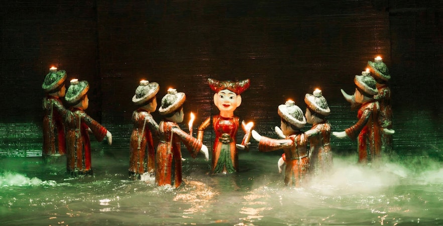 Thang Long Water Puppet Show with puppets performing on water stage in Hanoi, Vietnam.