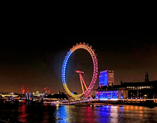 London Eye illuminated at night during Big Bus Panoramic Evening Tour.