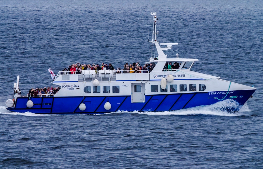 Ferry with passengers on Cliffs of Moher cruise in Ireland.
