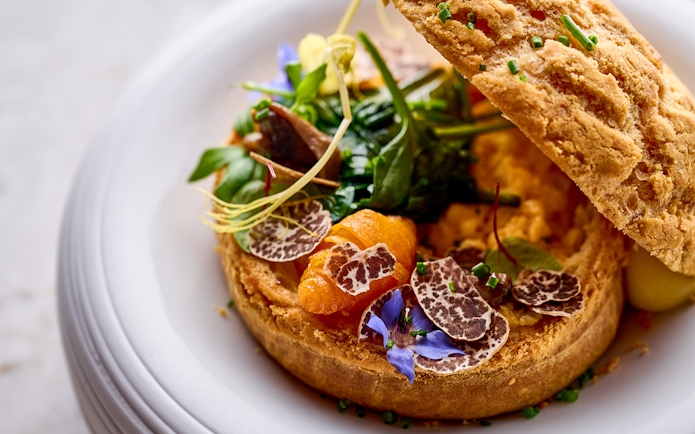 Gourmet dish with truffle slices and greens at At.Mosphere, Burj Khalifa.