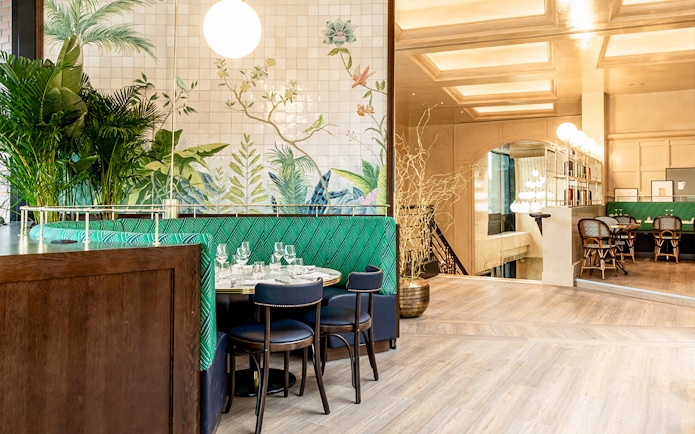 Dining area with green seating and botanical wall art at Flottille's snack & go.