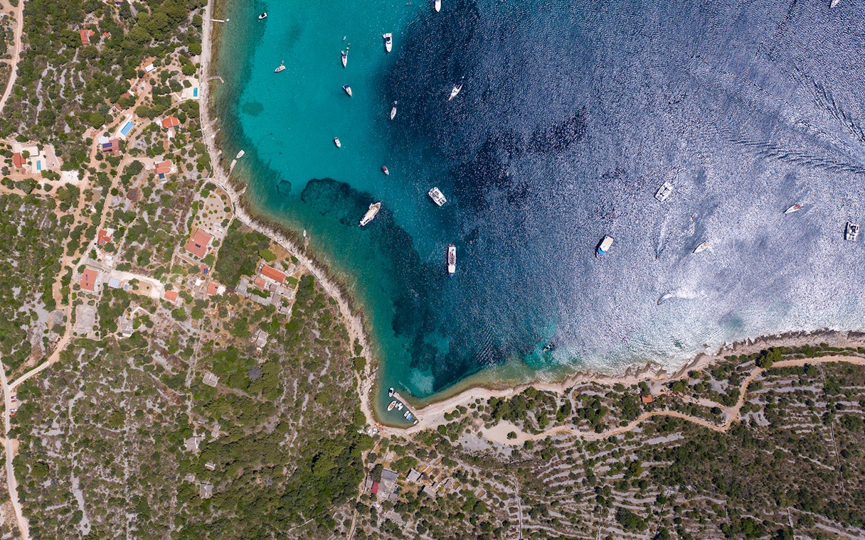 Aerial view of boats in Blue Lagoon, Split, with coastline and greenery.
