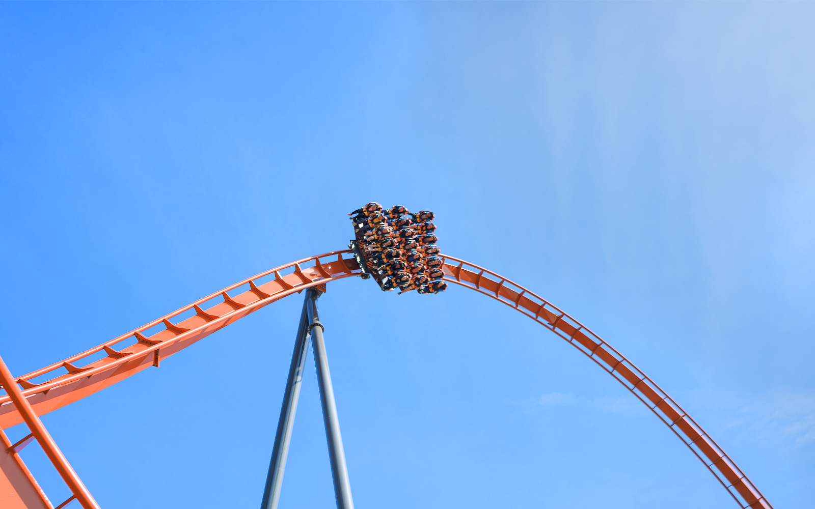 Roller coaster loop at Dorney Park's Iron Menace ride against blue sky.