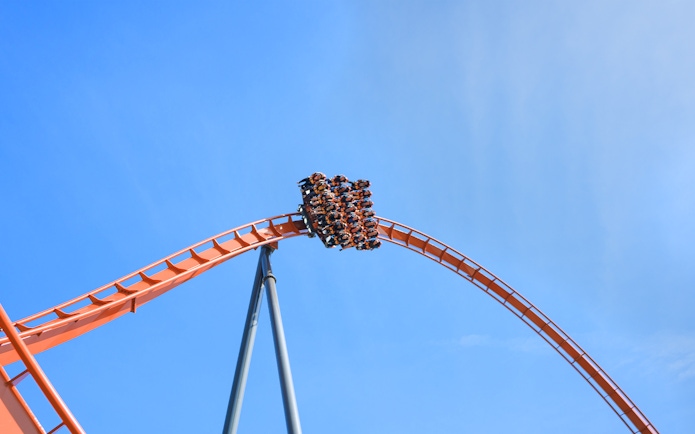 Roller coaster loop at Dorney Park's Iron Menace ride against blue sky.