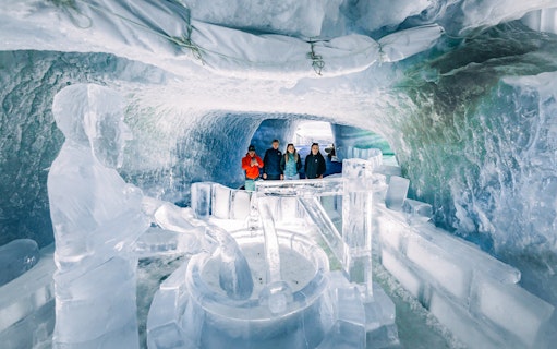 Visitors exploring ice sculptures inside Glacier Paradise.