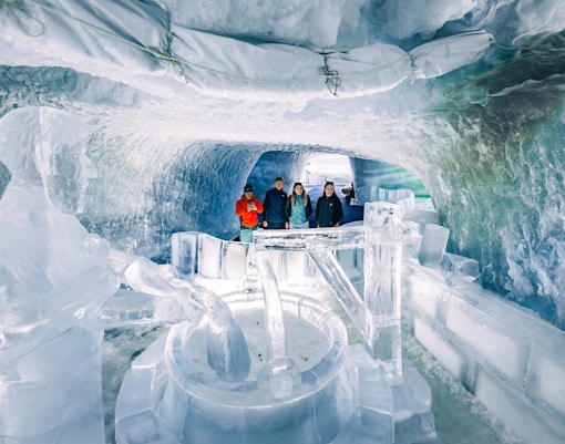 Visitors exploring ice sculptures inside Glacier Paradise.