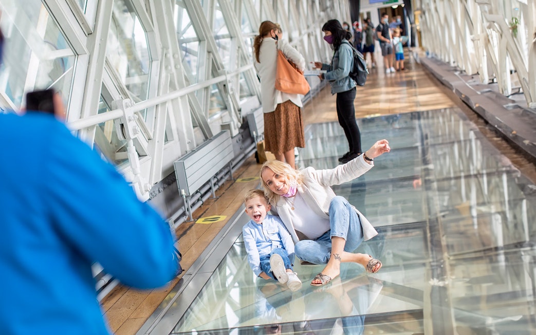 Visitors enjoying the glass walkway at Tower Bridge, London.
