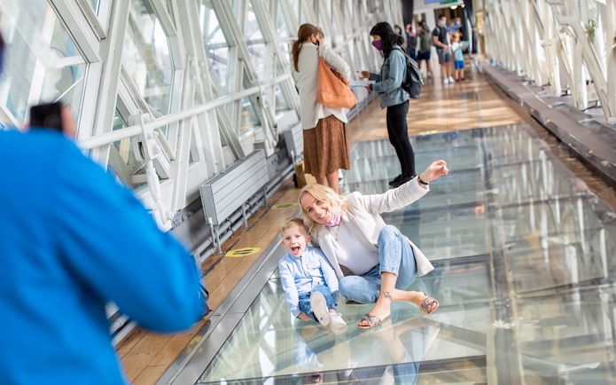 Visitors enjoying the glass walkway at Tower Bridge, London.