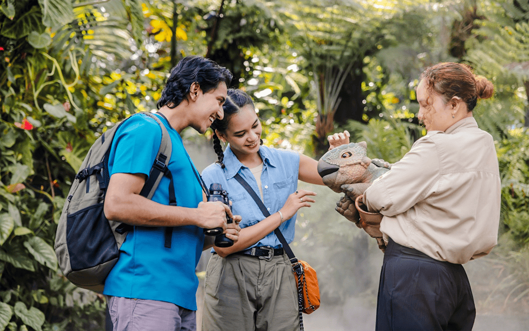Visitors interacting with a dinosaur puppet at Jurassic World experience, Gardens by the Bay.