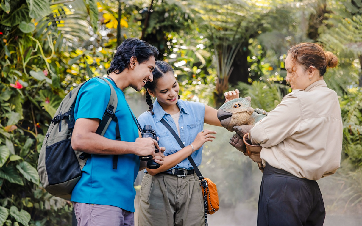 Visitors interacting with a dinosaur puppet at Jurassic World experience, Gardens by the Bay.