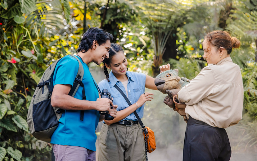 Visitors interacting with a dinosaur puppet at Jurassic World experience, Gardens by the Bay.