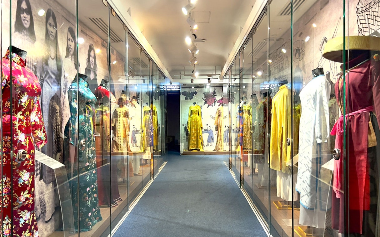Traditional Vietnamese dresses displayed in glass cases at Saigon Skydeck, Bitexco Financial Tower.