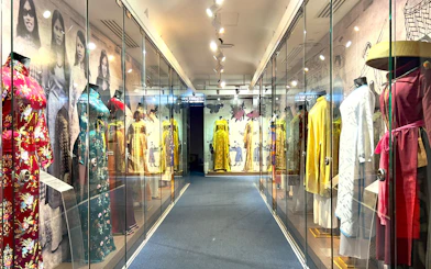 Traditional Vietnamese dresses displayed in glass cases at Saigon Skydeck, Bitexco Financial Tower.