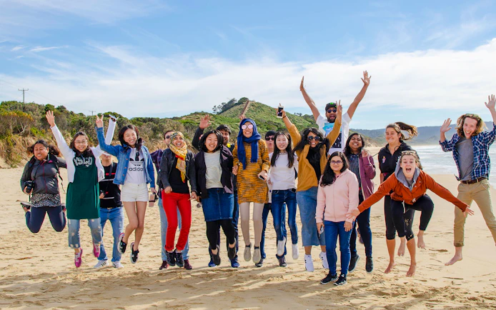 Group of people jumping on a beach during Bruny Island tour from Hobart.
