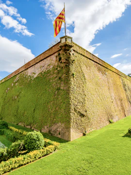 Montjuic Castle wall covered in ivy with Catalonia flag, Barcelona.