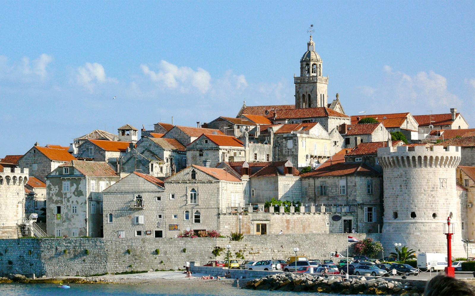 Historic stone buildings and a bell tower in Hvar town, Croatia, viewed from the waterfront.