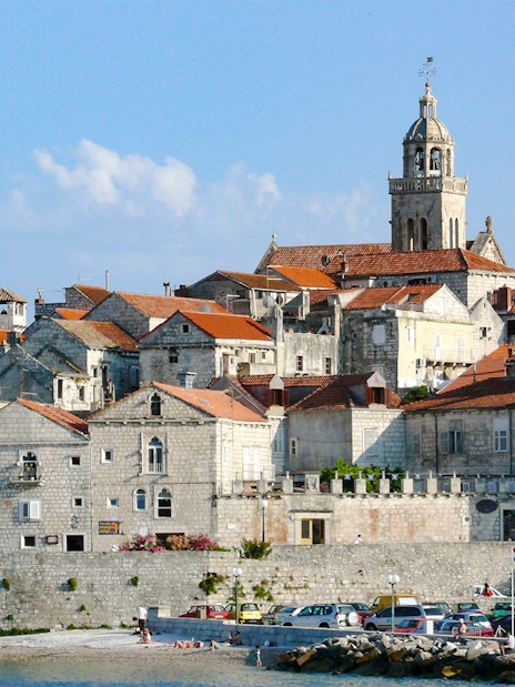 Historic stone buildings and a bell tower in Hvar town, Croatia, viewed from the waterfront.