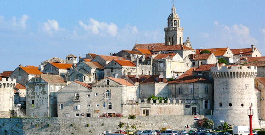 Historic stone buildings and a bell tower in Hvar town, Croatia, viewed from the waterfront.