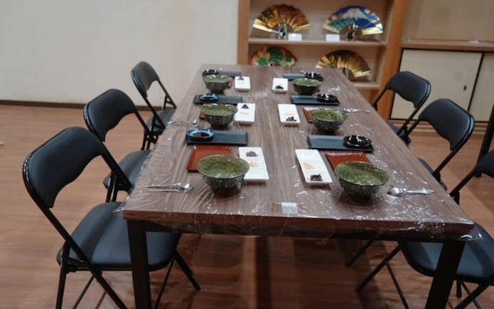 Dining table set for Kyoto mochi pounding experience with tasting bowls and utensils.