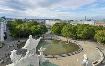 View from Karlskirche's panoramic terrace overlooking Vienna's cityscape and park.