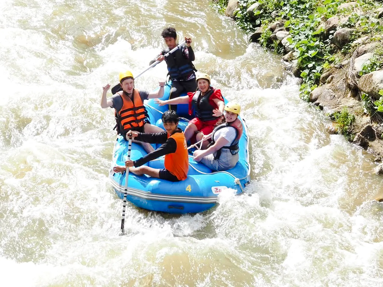 White water rafting group navigating rapids in Krabi jungle adventure.