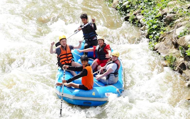 White water rafting group navigating rapids in Krabi jungle adventure.