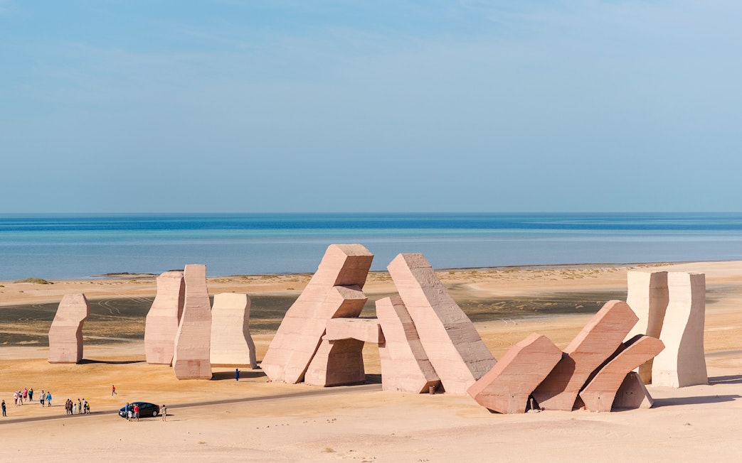 Gate of Allah sculptures at Ras Muhammad National Park, Egypt, with tourists and Red Sea backdrop.