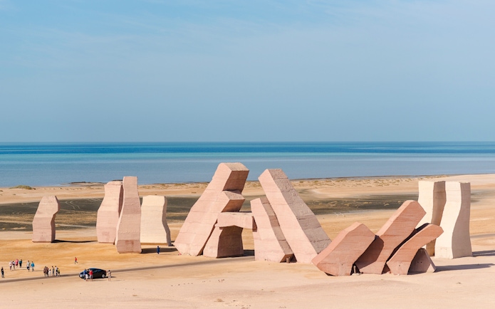 Gate of Allah sculptures at Ras Muhammad National Park, Egypt, with tourists and Red Sea backdrop.