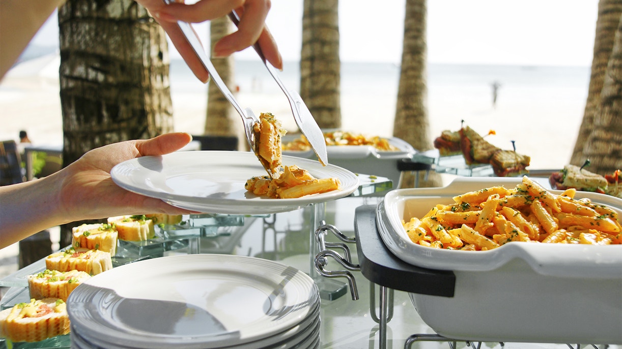 Tropical lunch buffet with pasta and seafood on Moreton Island beach.