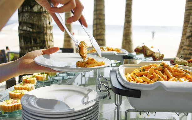 Tropical lunch buffet with pasta and seafood on Moreton Island beach.