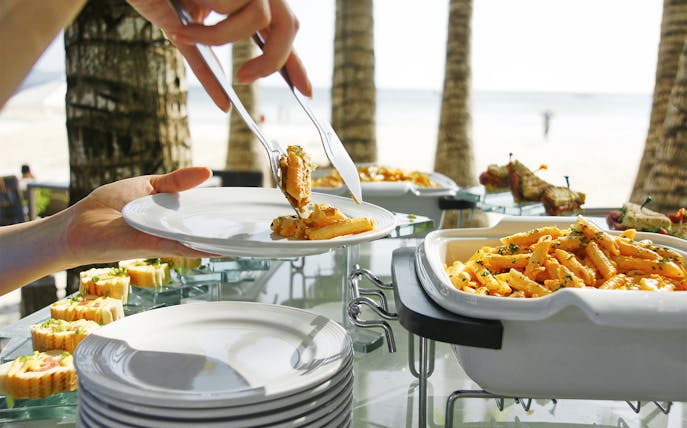 Tropical lunch buffet with pasta and seafood on Moreton Island beach.