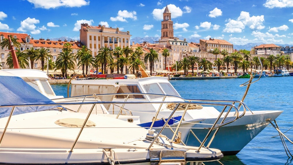 Moored boats with view of Split's Old Town and bell tower on the Adriatic coast, Croatia.