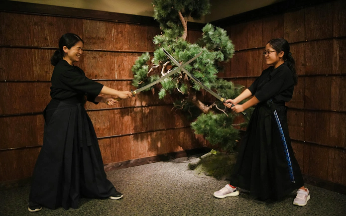 Two people practicing samurai sword techniques in Shinjuku.