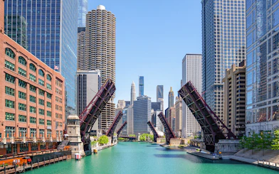 Chicago River with raised lift bridges and skyline during architecture cruise.