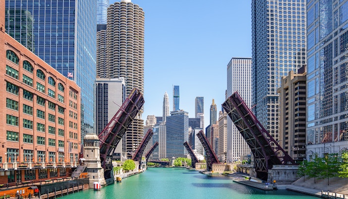 Chicago River with raised lift bridges and skyline during architecture cruise.